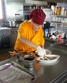 03 Die Chefin beim Anrichten der Speisen